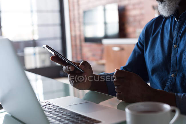 Seniorin benutzt Handy im heimischen Wohnzimmer — Stockfoto