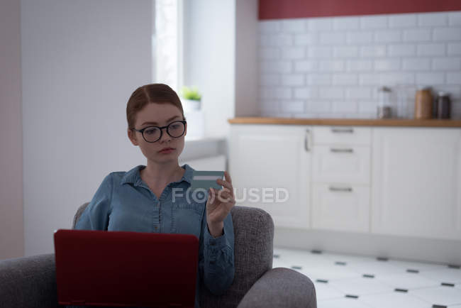 Frau erledigt Online-Einkauf am Laptop mit Kreditkarte zu Hause — Stockfoto