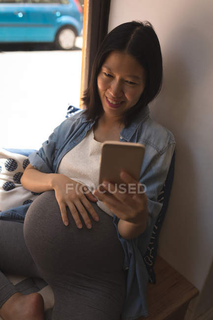 Беременная женщина говорит селфи с мобильного телефона в кафе — стоковое фото