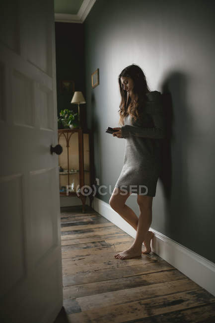 Femme utilisant un téléphone portable à la maison — Photo de stock