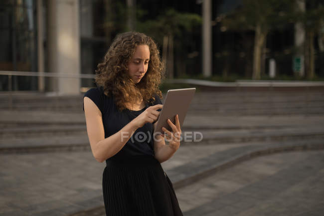 Schöne Frau mit digitalem Tablet an einem sonnigen Tag — Stockfoto