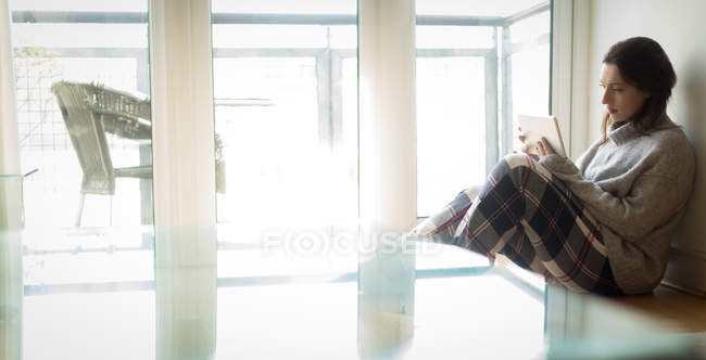 Woman using digital tablet in living room at home. — Stock Photo