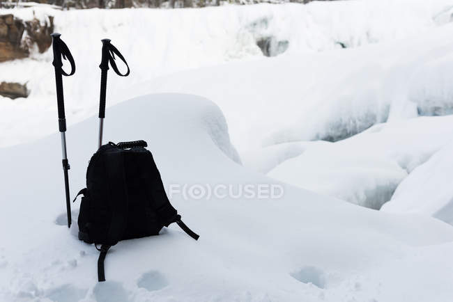 Zaino con bastoncini da sci su un paesaggio innevato durante l'inverno — Foto stock