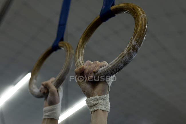 Athlete woman hanging on gym ring at fitness studio — Stock Photo