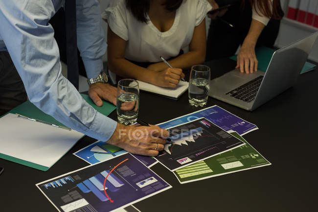 Ділові колеги обговорюють графічний документ в офісі — стокове фото