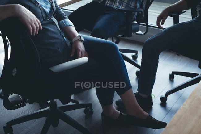 Compañeros de negocios que interactúan entre sí en una reunión en la oficina - foto de stock