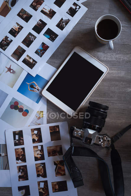 Overhead view of digital tablet, camera and documents on a table — Stock Photo