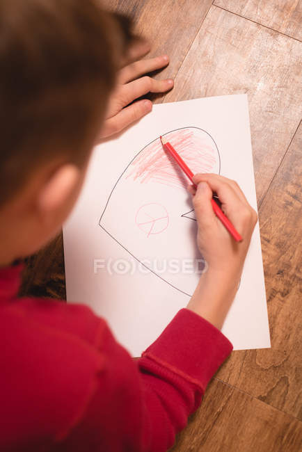 Garçon dessin sur papier artisanal à la maison — Photo de stock