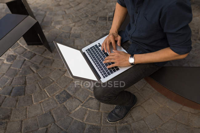 Partie médiane de l'homme en utilisant un ordinateur portable dans le café trottoir — Photo de stock