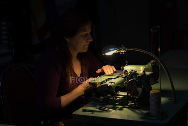 Sastre de tela de coser con máquina de coser en sastrería - foto de stock