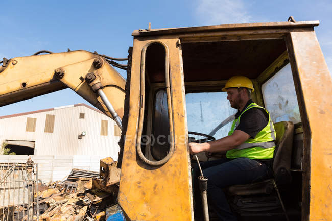 Worker operating the crane in the scrapyard — Stock Photo