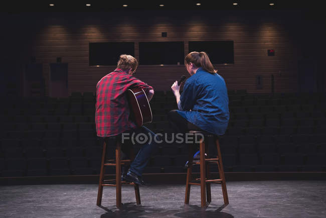 Singer and musician performing on stage at theatre. — Stock Photo