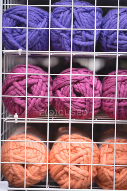 Pallina di filato multicolore tenuta sullo scaffale in sartoria — Foto stock