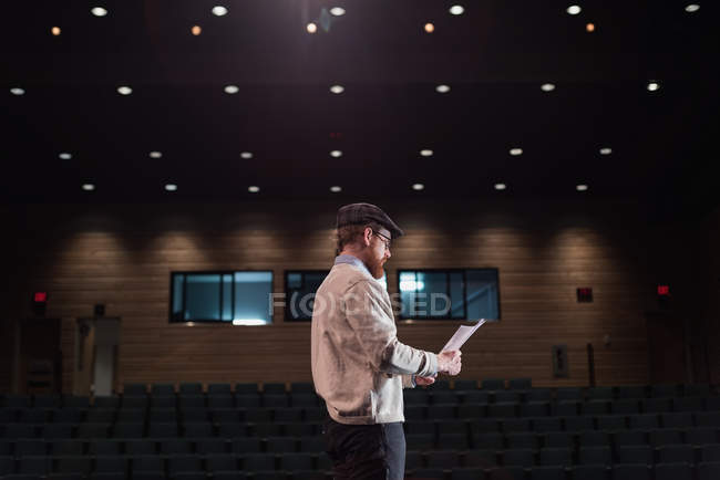 Männlicher Schauspieler liest Drehbuch auf der Bühne im Theater. — Stockfoto