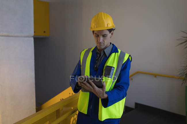 Работник мужчина, использующий цифровой планшет в офисе солнечной станции — стоковое фото