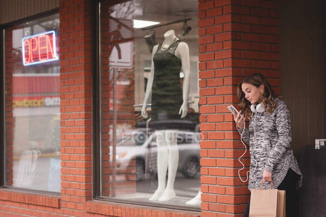 Menina bonita usando telefone celular fora do shopping — Fotografia de Stock