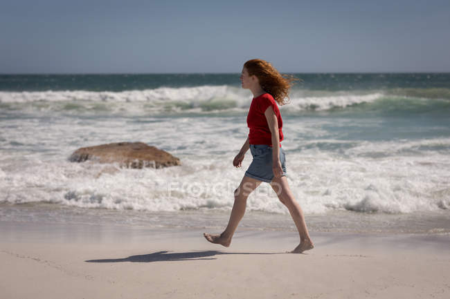 Schöne Frau zu Fuß auf Sand am Strand, Seitenblick — Stockfoto