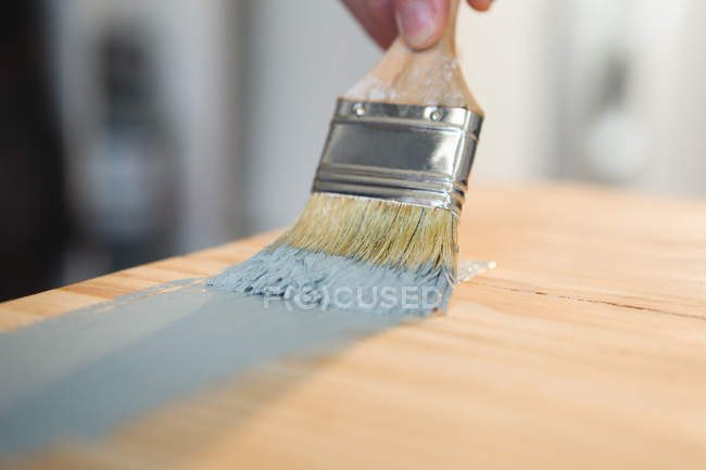 Close-up de carpinteiro masculino pintando uma mesa — Fotografia de Stock