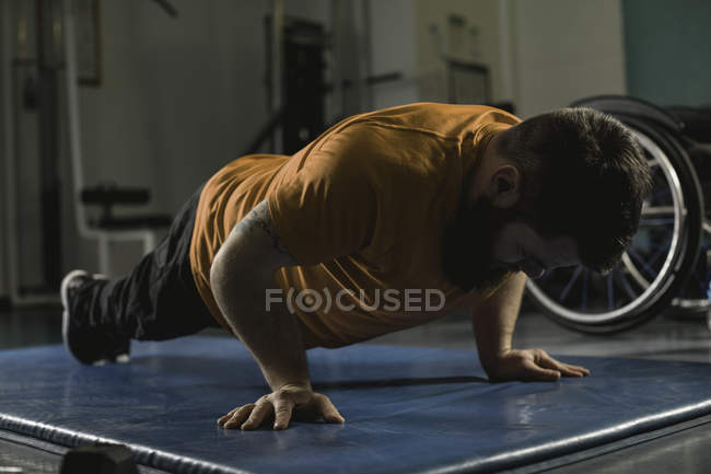 Handicapped man doing pushup in gym — Stock Photo