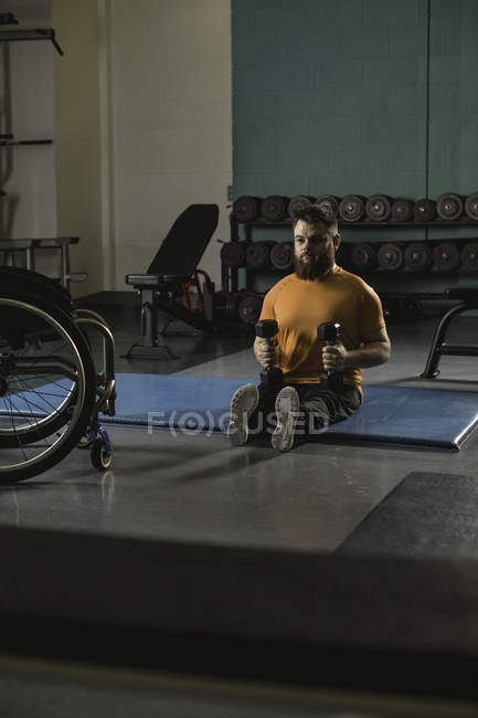 Homem deficiente exercitando-se com halteres no ginásio — Fotografia de Stock