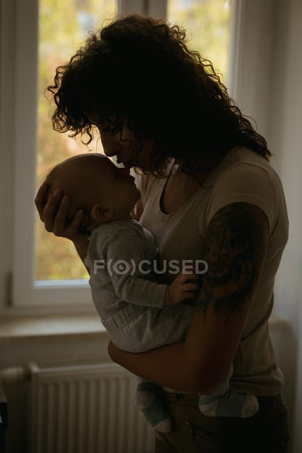 Madre baciare il suo bambino a casa — Foto stock
