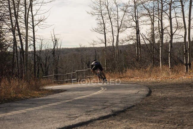 Вид ззаду велосипедист, що їде на гірському велосипеді на дорозі — стокове фото