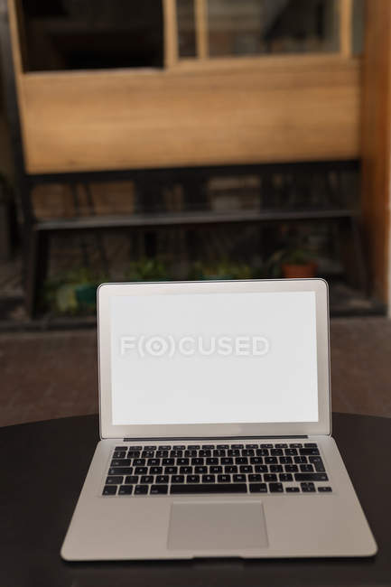 Laptop on table in pavement cafe — Stock Photo