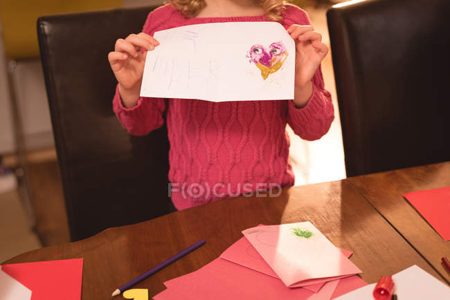 Metà sezione di ragazza che mostra la carta di San Valentino a casa — Foto stock