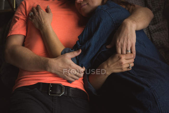 Paar umarmt sich im heimischen Wohnzimmer — Stockfoto