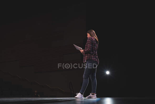 Female actress reading script on stage at theatre. — Stock Photo