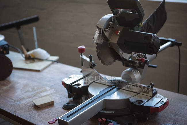 Nahaufnahme einer elektrischen Säge auf einem Holztisch in der Werkstatt — Stockfoto