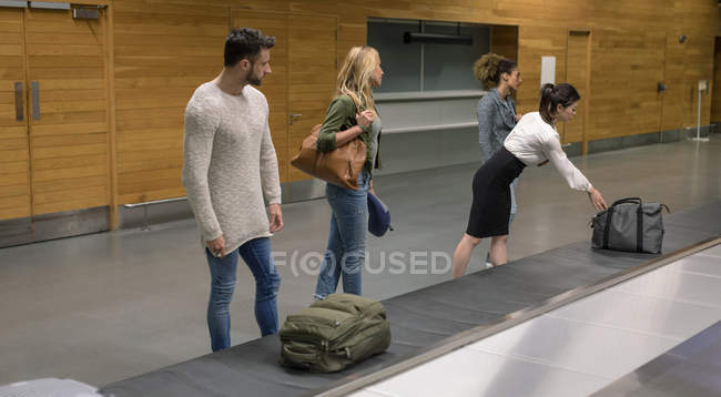 Комп'ютери, які беруть свій багаж з каруселі в аеропорту — стокове фото
