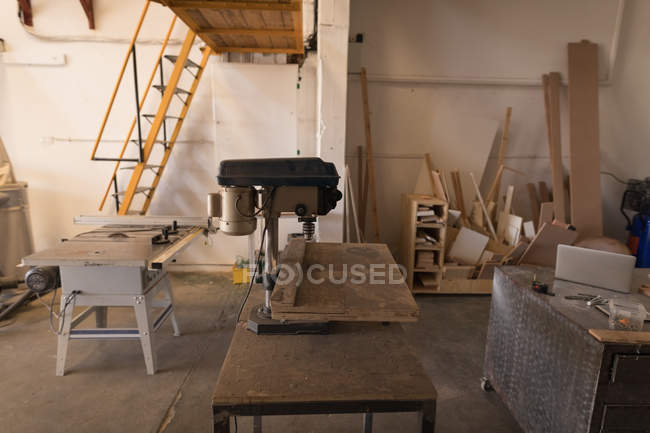 Vertical drilling machine on table in workshop interior. — Stock Photo