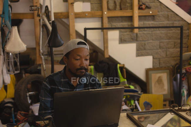 Уважний чоловік використовує ноутбук у майстерні — стокове фото