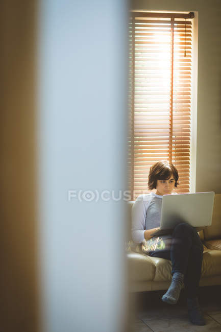 Жінка використовує ноутбук у вітальні вдома — стокове фото