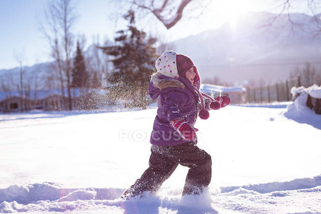 Carefree girl walking in snow during winter — Stock Photo