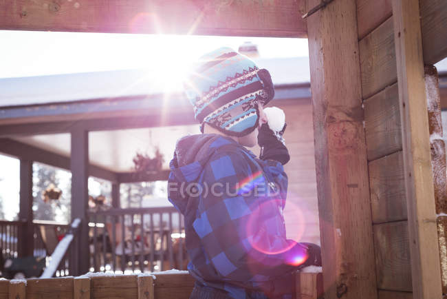 Bonito menino segurando bola de neve durante o inverno — Fotografia de Stock