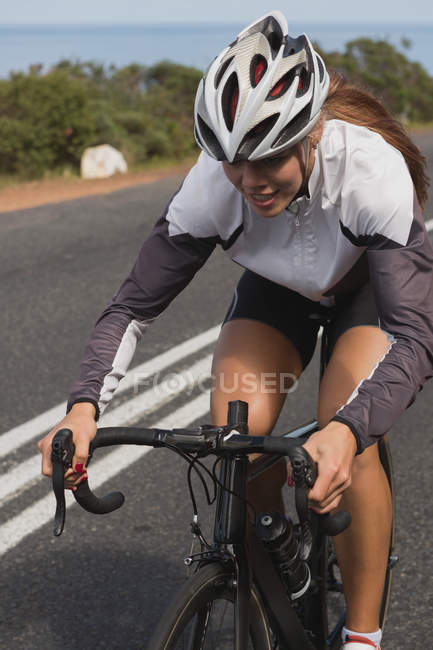 Biker riding mountain bike on road on a sunny day — Stock Photo