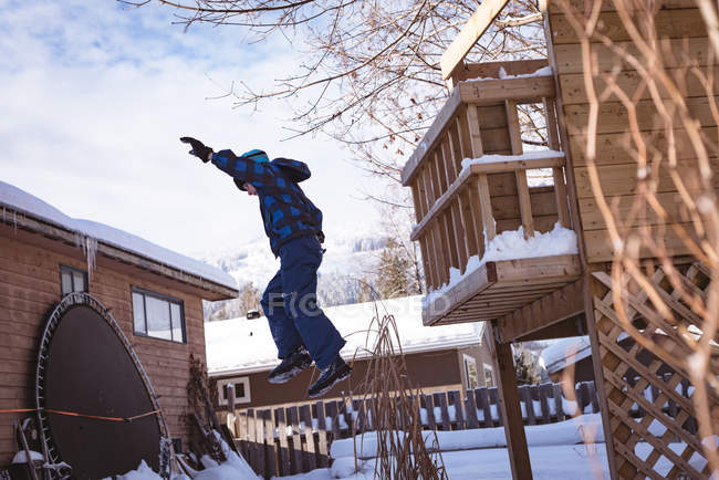 Boy playing in snow covered playground during winter — Stock Photo