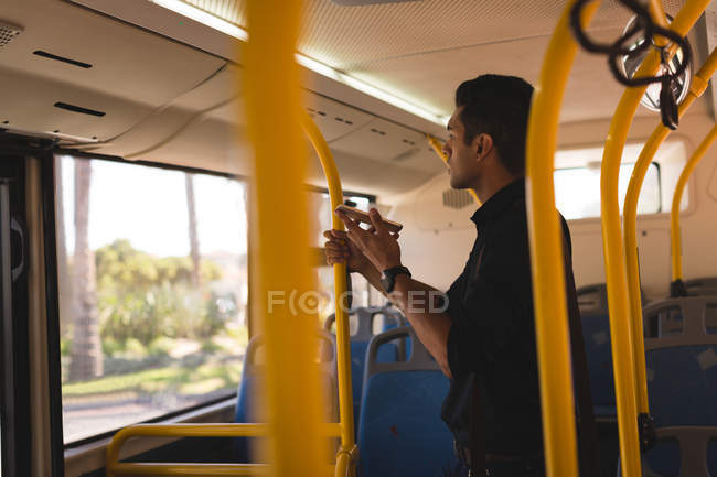 Giovane uomo d'affari che parla sul cellulare mentre viaggia in autobus — Foto stock
