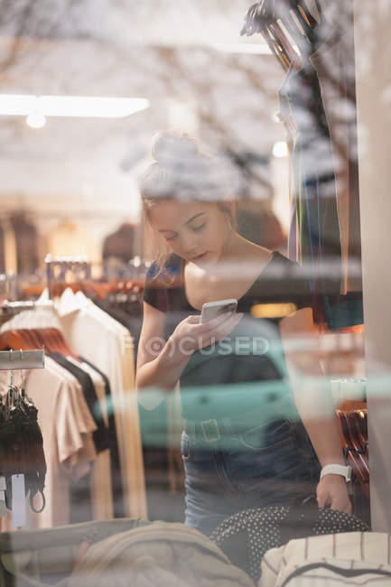 Красивая девушка с помощью мобильного телефона во время покупок в торговом центре — стоковое фото