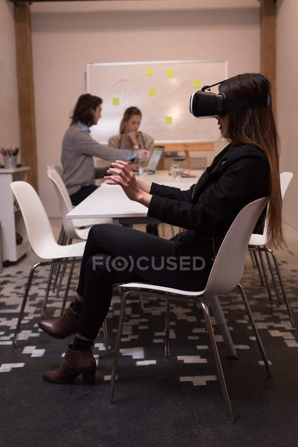Женщина-руководитель, использующая гарнитуру виртуальной реальности в офисном интерьере
. — стоковое фото