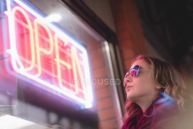 Hermosa chica mirando a la pantalla fuera del centro comercial - foto de stock