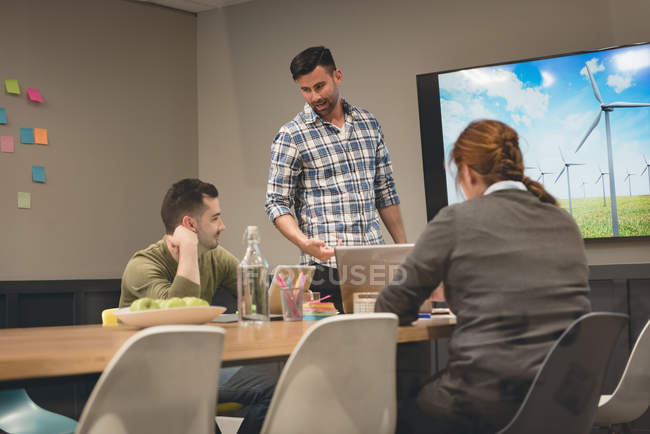 Geschäftskollegen interagieren im Besprechungsraum im Büro miteinander — Stockfoto