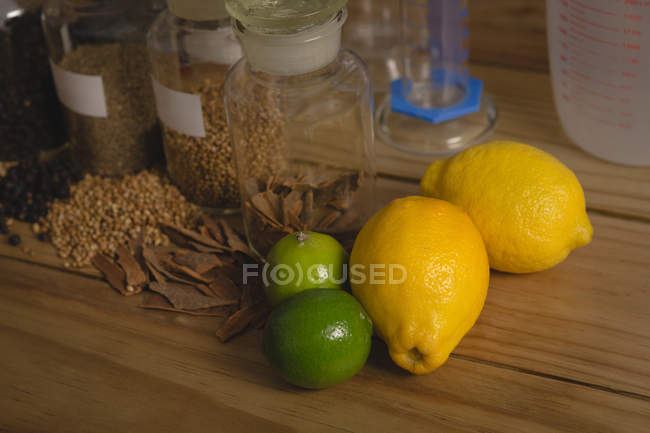 Primer plano de ingredientes de limón y especias en la mesa en la fábrica de ginebra - foto de stock
