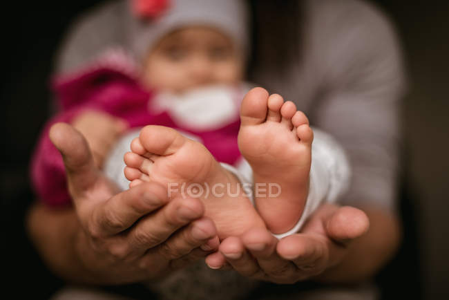 Sección media del padre sosteniendo al bebé en la mano - foto de stock