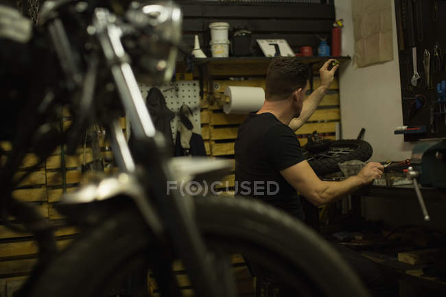 Mécanicien vérifiant un écrou dans le garage — Photo de stock