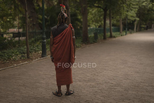 Вид сзади на человека Масаи, стоящего на дорожке в парке — стоковое фото