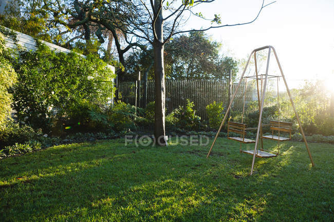 Balanço vazio no jardim em um dia ensolarado — Fotografia de Stock