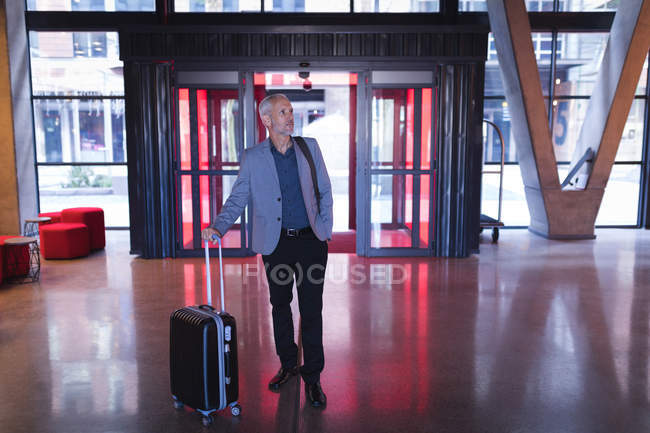 Бізнесмен, який входить в готель з багажем — стокове фото